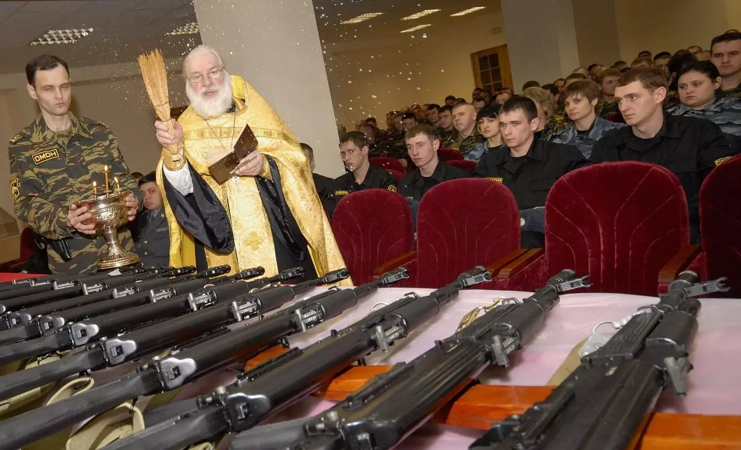 Священник освящает оружие