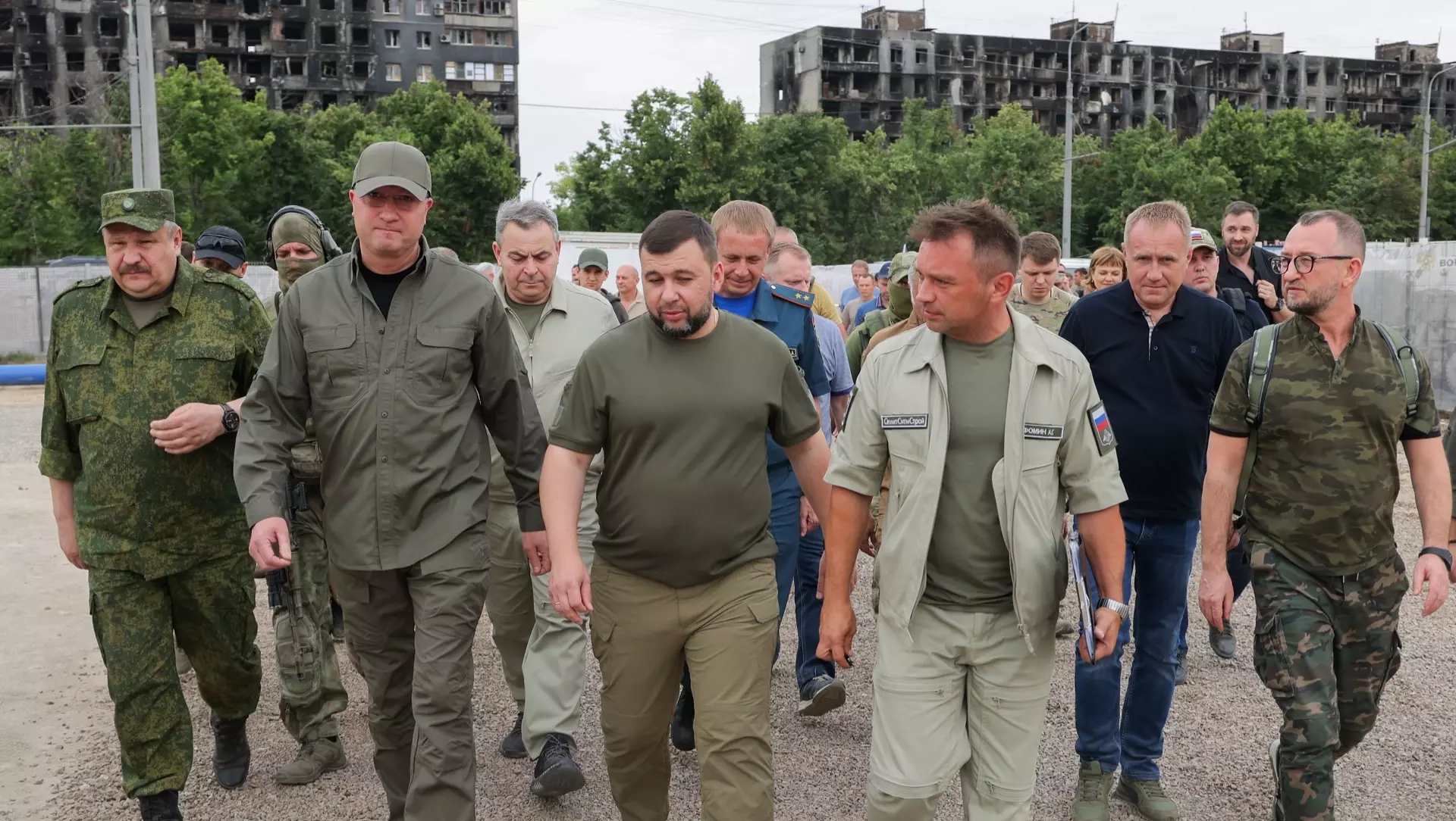 Заместитель министра обороны РФ Тимур Иванов (второй слева на первом плане) и глава ДНР Денис Пушилин (в центре на первом плане) на строительной площадке