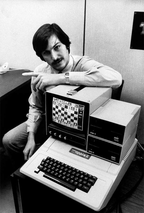 Стив Джобс позирует с компьютером Apple-II с загруженной игрой «Шахматы»