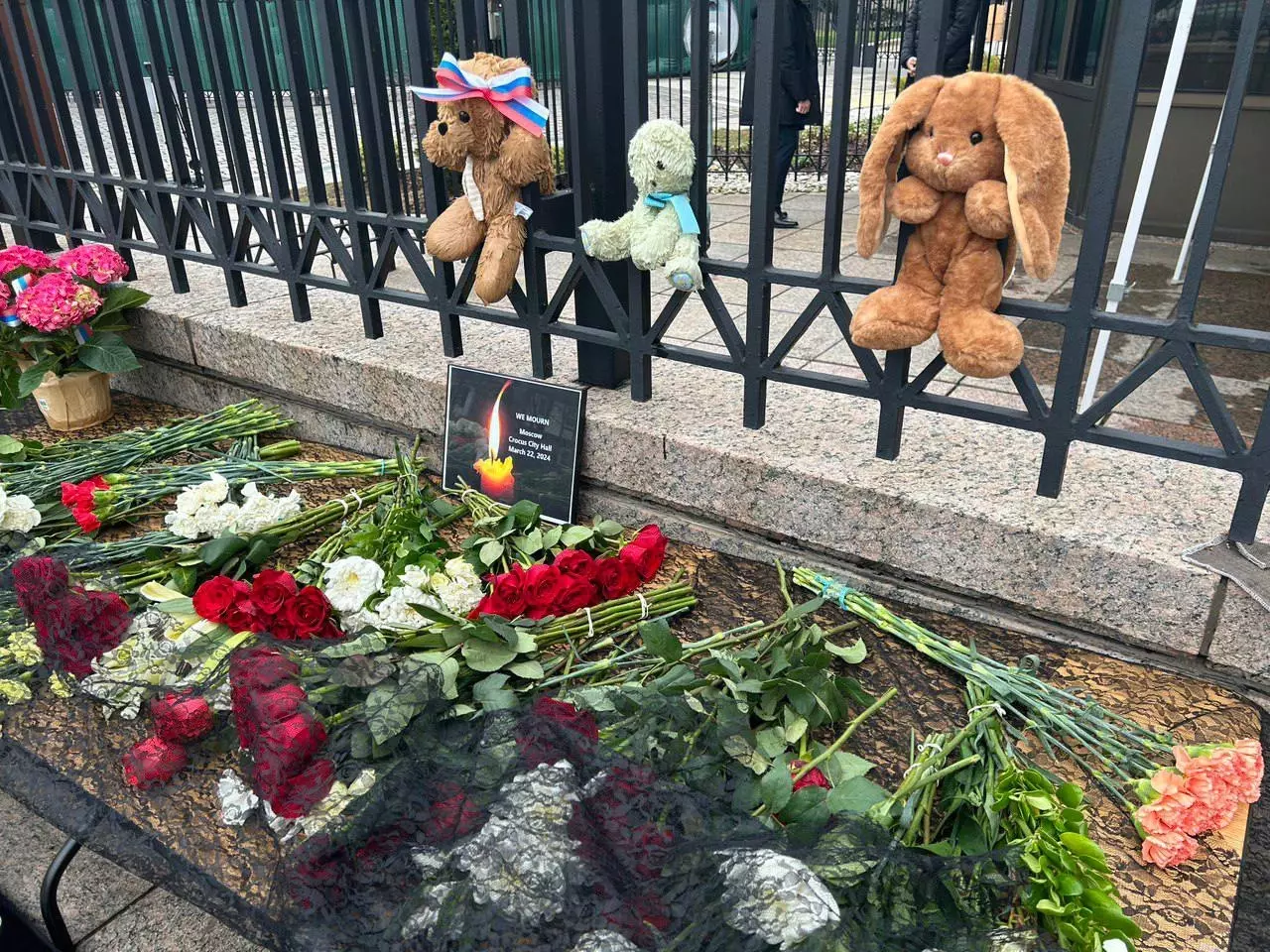 По всему миру люди несут цветы к посольству России в память о жертвах теракта в Крокусе.
