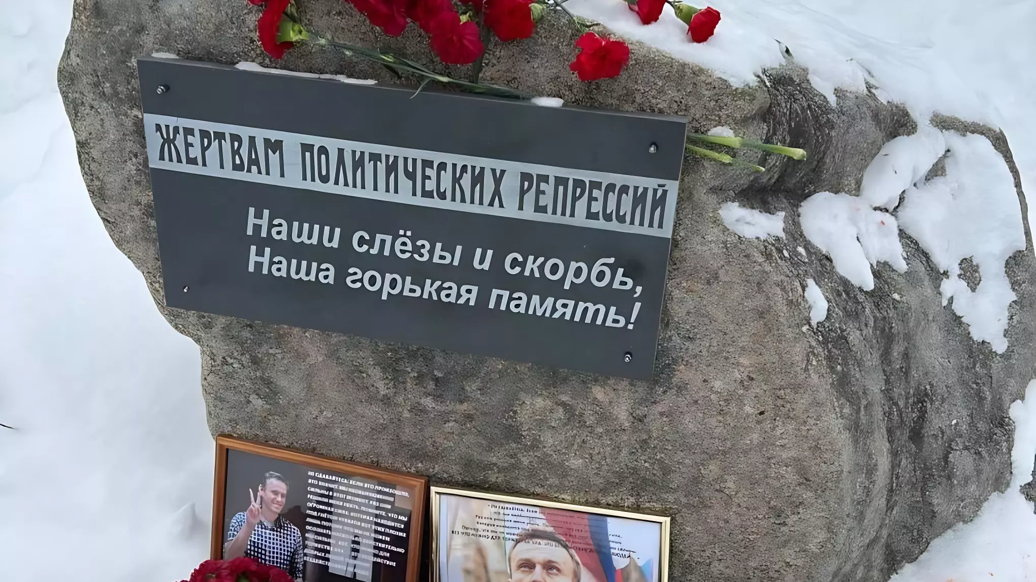 Памятник жертвам политических репрессий в Костроме с портретом Алексея Навального и букетами цветов.